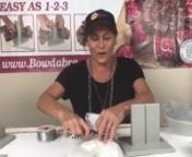 Watch Sandy Sandler as she makes some DIY wedding bows, wrist corsage, head bows, pew bows and more at this week’s Facebook Live. nnPretty Ponytail Holder/Pew Bow nnSandy begins the project with two beautiful dovetailed white ribbons (1 yard each). She scrunches them in the Large Bowdabra, making loops. She tops it with a pretty glitter tulle (8” long) and adds some pretty pink rose picks over it. She ties it all to finish the cute little ponytail holder that can also be used as a bridesmaid